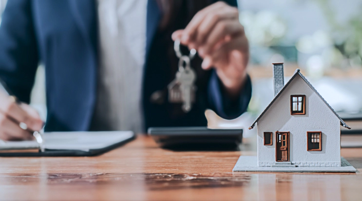 appraiser writing and holding key on background of mini house model russellville ar
